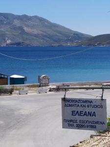 um sinal na frente de uma massa de água em Eleana Studios em Skiros