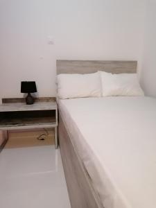 a bedroom with a bed and a desk with a laptop at Jz Plus Classio in Rhodes Town