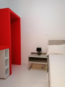 a bedroom with a red bed and a desk at Jz Plus Classio in Rhodes Town