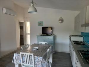 a kitchen with a table with two chairs and a television at Casa Maria in Siniscola