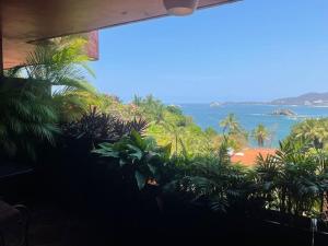 una vista sull'oceano da una stanza con piante di Vista de las Rocas a Ixtapa