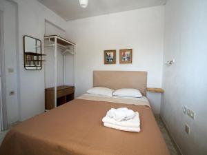 a bedroom with a bed with towels on it at Theodora in Patitiri