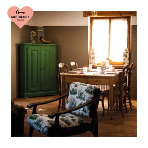 comedor con mesa y puerta verde en Maison Coromandel, en Aymavilles