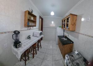 małą kuchnię ze stołem i kuchenką mikrofalową w obiekcie Apartamento à 5min à pé da Praia w mieście Ubatuba