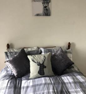 ein Bett mit Kissen darauf im Schlafzimmer in der Unterkunft Captivating 2-Bed Apartment in Isle of Bute in Rothesay