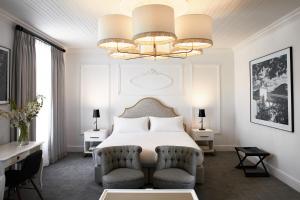 a bedroom with a bed and two chairs and a chandelier at The Alphen Boutique Hotel & Spa in Cape Town +48 photos