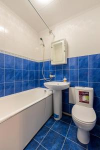 Baño de azulejos azules con aseo y lavamanos en Уютная квартира на Печерске, en Kiev