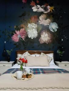 una camera da letto con un letto e un dipinto di fiori di Niños Hotel Fierro a Cuzco