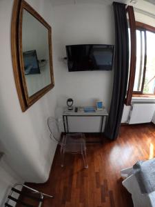 ローマにあるEMI's Guest Houseのテーブル、鏡、テレビが備わる客室です。