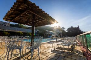 un gruppo di sedie seduto su un patio con piscina di Hotel Fazenda Bavaria a São Lourenço
