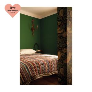 1 dormitorio con 1 cama con paredes verdes en Maison Coromandel, en Aymavilles
