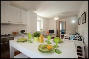 a kitchen with a table with plates of fruit on it at Casa do Joaquim da Praia in Nazaré