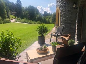 a patio with a bench and potted plants on it at Apartmány na Táloch 107 & 108 Chopok - Juh in Tale