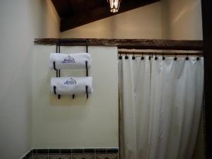 a bathroom with towels on a shower curtain at Hotel Casa Madeleine B&B & Spa in Antigua Guatemala