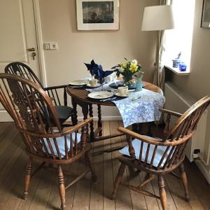 een eettafel met stoelen en een tafel met bloemen erop bij TimeOut-Breda in Breda