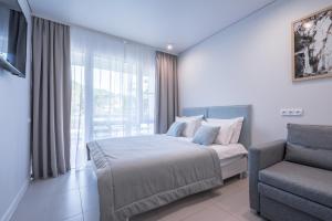 - une chambre avec un lit, une chaise et une fenêtre dans l'établissement The summer suites, à Shepsi