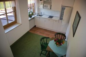 uma pequena cozinha com uma mesa e cadeiras e um lavatório em Alpenhotel Bergzauber em Berchtesgaden