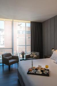 una habitación de hotel con una bandeja de comida en una cama en Hotel 15 de Mayo en Mar del Plata