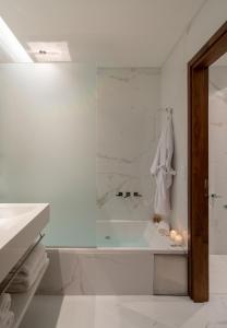a white bathroom with a tub and a shower at Hotel 15 de Mayo in Mar del Plata