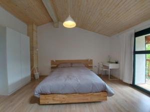 una camera con letto e testata in legno di Apartmaji Hedera a Komen