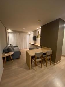 ein Wohnzimmer mit einem Tisch, Stühlen und einem Sofa in der Unterkunft Gramado Resort Apart in Gramado