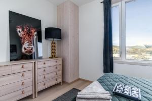 a bedroom with a dresser with a painting of a giraffe at MJOS TOWER Apartment - Lovely city view in Ringsaker