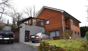 a car parked in front of a brick house at Les Cinq Francais in Nismes