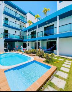 ein Gebäude mit einem Swimmingpool vor einem Gebäude in der Unterkunft Porto Flats in Porto De Galinhas