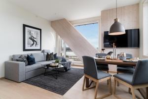 a living room with a couch and a table at MJOS TOWER Apartment - Lovely city view in Ringsaker