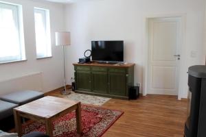 a living room with a flat screen tv on a cabinet at Strandvilla Sophie App 1 in Dierhagen