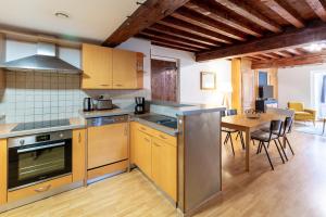 a kitchen with yellow cabinets and a table and a dining room at Le Saint Jean in Crémieu