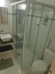uma casa de banho com um chuveiro, um WC e um lavatório. em Enseada- 400m Aquário. Apt espaçoso e aconchegante no Guarujá