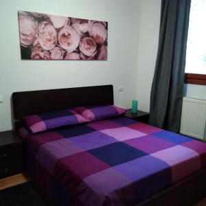 Dormitorio con cama con manta púrpura y púrpura en Casa Marta, en Cividale del Friuli