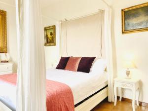 una camera con un letto bianco a baldacchino di Medieval Cosy Getaway a Giuliano di Roma