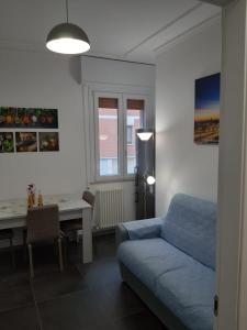 a living room with a blue couch and a table at Appartamento appena ristrutturato in Ferrara
