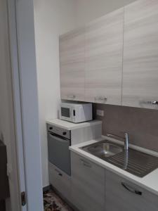a small kitchen with a sink and a microwave at Appartamento appena ristrutturato in Ferrara