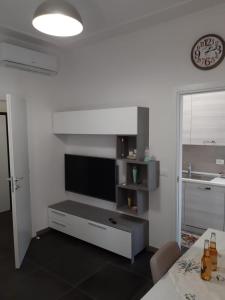 a living room with a flat screen tv and a kitchen at Appartamento appena ristrutturato in Ferrara