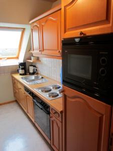 uma cozinha com um fogão e um micro-ondas em Ferienhof Böhnke Nr4 em Puttgarden
