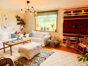 uma sala de estar com um sofá branco e uma mesa em Super cosy cottage in heart of Dalarna em Västra Fors