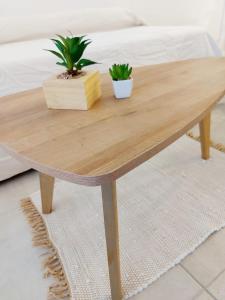 a wooden coffee table with two potted plants on it at Luminosos y modernos departamentos en Rosario in Rosario