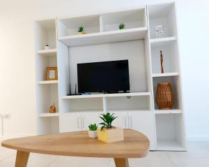 sala de estar con TV y mesa de madera en Luminosos y modernos departamentos en Rosario en Rosario