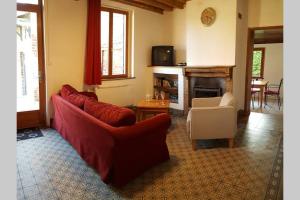 een woonkamer met twee rode banken en een open haard bij Gîte du bocage in Buysscheure