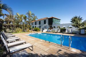 uma piscina com espreguiçadeiras ao lado de um edifício em Hotel El Patio em Garachico