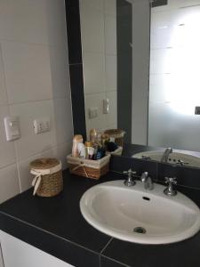 y baño con lavabo y espejo. en Paracas departamento Condominio Nautico, en Paracas