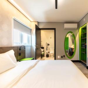 um quarto com uma cama grande e um espelho verde em Tru By Hilton Criciúma em Criciúma
