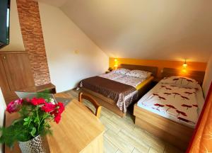 a small room with a bed and a table with flowers at Guesthouse Mesec Zaplana in Vrhnika