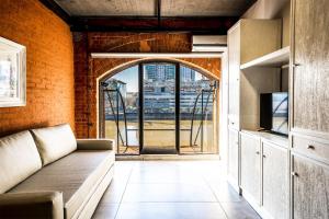 a living room with a couch and an open window at Madero Homes in Buenos Aires