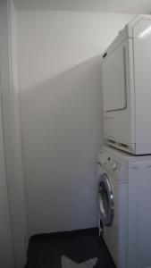 a laundry room with a washing machine and a microwave at All-in-One Apartment mit eigener Sonnenterrasse im Garten in Düsseldorf