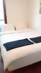 a white bed with a blue blanket on it at Budget Small Room City Centre in Oslo