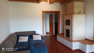 a living room with a couch and a fireplace at Vértestolna Vendégház in Vértestolna